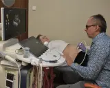Lekarz wykonuje usg 3 trymestru. Na ekranie widać obraz dziecka, a pacjentka leży spokojnie.
