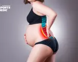 Ciężarna kobieta odczuwa ból w dolnej części pleców, wskazujący na rwa kulszowa w ciąży.