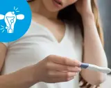 Kobieta z niepokojem patrzy na test ciążowy. Ikona symbolizuje problemy z płodnością, takie jak endometrioza a ciąża.