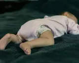 Niemowlę śpi na brzuchu na miękkim kocyku. Czy niemowlę może spać na brzuchu? To pytanie nurtuje wielu rodziców.