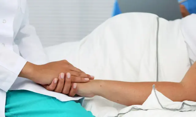 Lekarz uspokaja pacjentkę przed amniopunkcją, podkreślając, że amniopunkcja ryzyko jest minimalne.