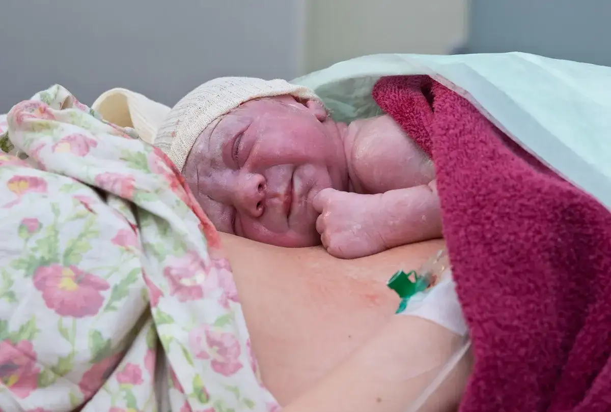 Nowe życie, pierwsze kangurowanie. Maluszek wtulony w mamę, otulony kocykami, czuje ciepło i bezpieczeństwo.