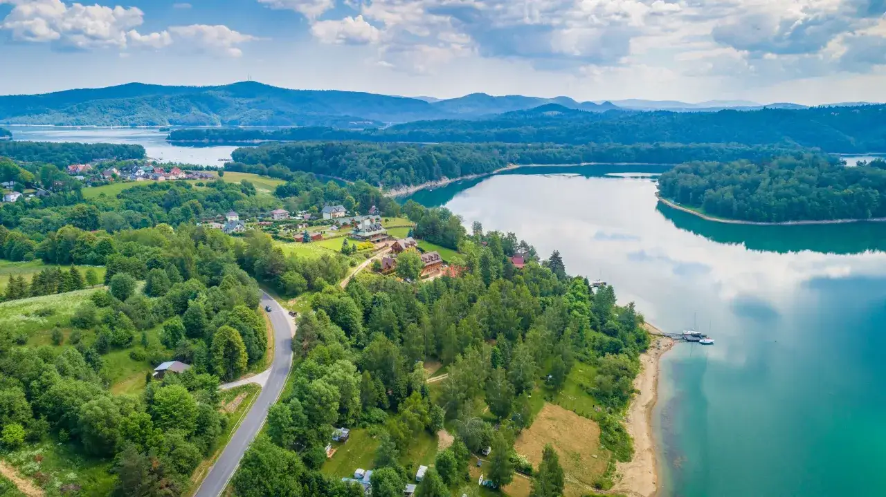 Malownicze jezioro otoczone lasami i domkami. Idealne miejsce, gdzie z dzieckiem na weekend, by odpocząć i cieszyć się naturą.