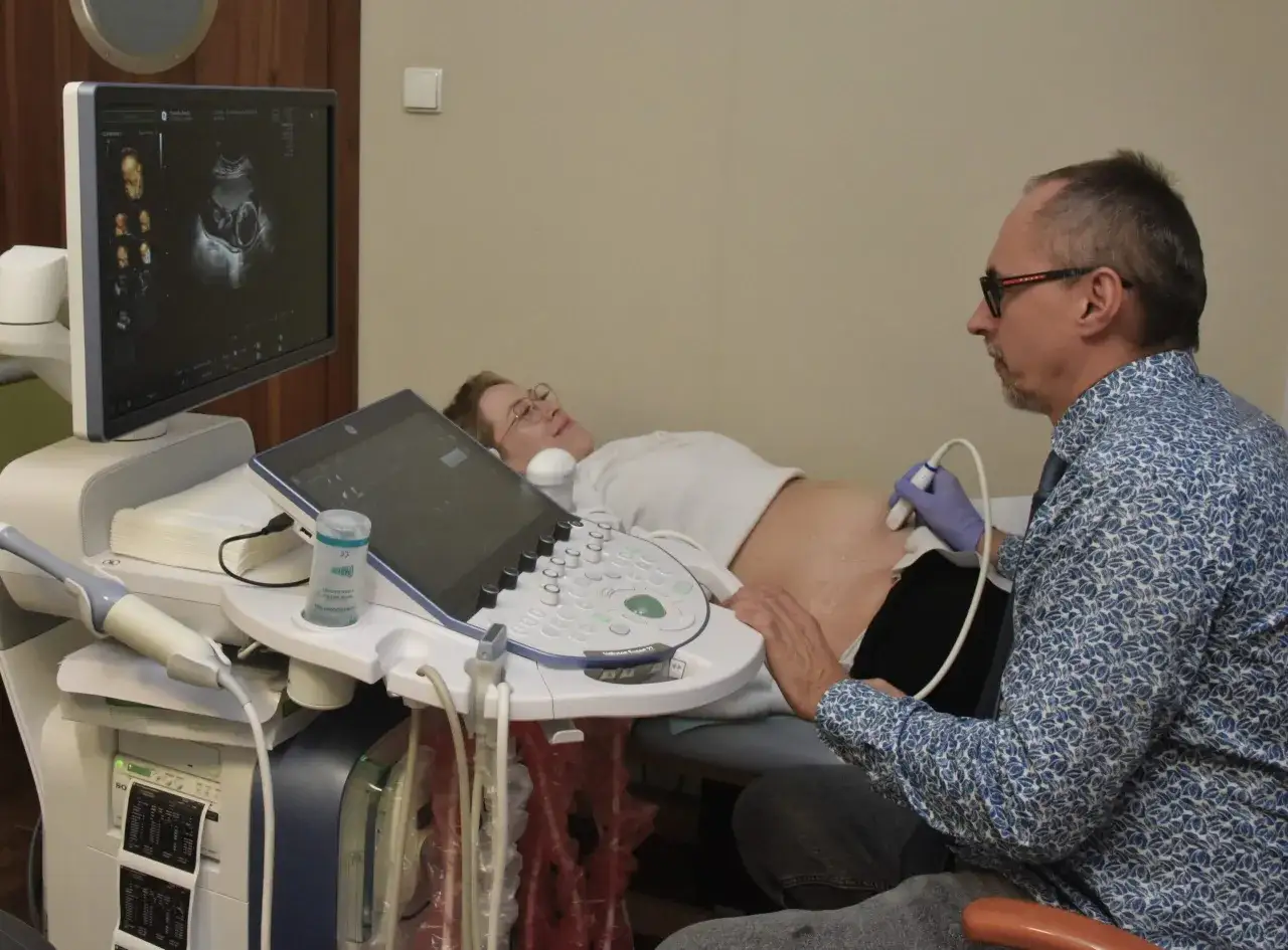 Lekarz wykonuje usg 3 trymestru. Na ekranie widać obraz dziecka, a pacjentka leży spokojnie.